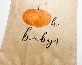 May include: A brown paper bag with a watercolor pumpkin and the text "oh baby!" printed on it.