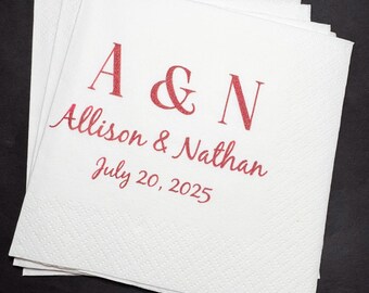 May include: A stack of white paper napkins with red glitter lettering. The text reads "A & N" above "Allison & Nathan" and "July 20, 2025". The napkins have a subtle, textured pattern.