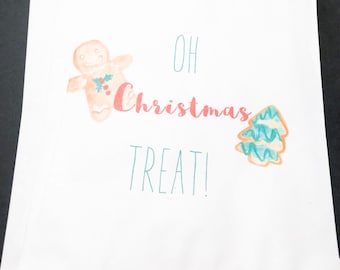 May include: White paper gift bag with a gingerbread man and a Christmas tree design. The bag has the text "Oh Christmas Treat!" printed on it.