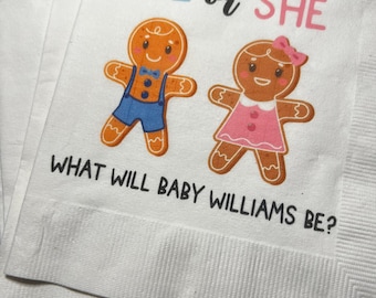 Peut inclure: Serviettes en papier blanches sur le thème de la révélation du sexe. Les serviettes présentent un bonhomme et une femme en pain d'épices, avec le texte "HE or SHE" en bleu et rose, et "WHAT WILL BABY WILLIAMS BE?" en noir.