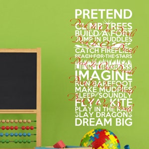 May include: White wall decal with the words "PRETEND", "IMAGINE", and "DREAM BIG" in a playful font. The words are arranged vertically and are surrounded by other words related to childhood activities, such as "climb trees", "build a fort", and "play in the rain".