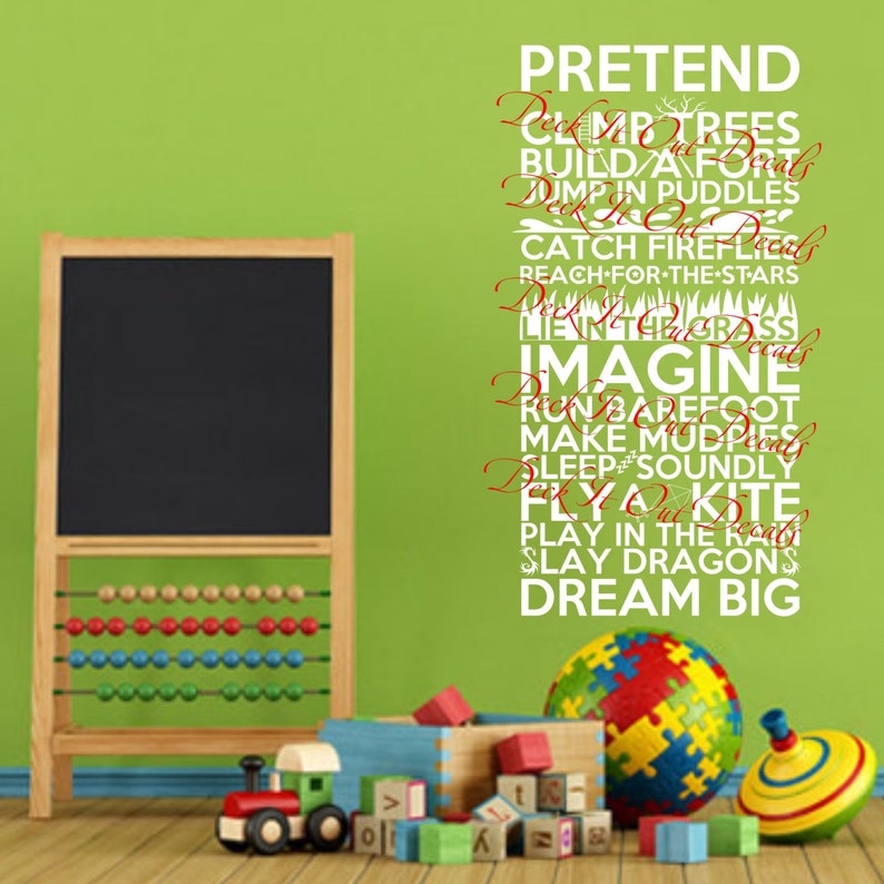 May include: White wall decal with the words "PRETEND", "IMAGINE", and "DREAM BIG" in a playful font. The words are arranged vertically and are surrounded by other words related to childhood activities, such as "climb trees", "build a fort", and "play in the rain".