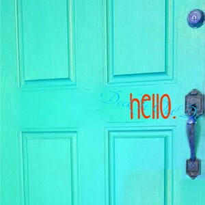 Puede incluir: Una puerta de madera turquesa con moldura blanca y un tirador de puerta plateado. La palabra "hello" está escrita en rojo en la puerta.