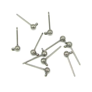 May include: A collection of silver-toned jewelry findings including several ball-post earring studs with small loops, a group of open jump rings, and a set of flower-shaped earring backs, all displayed as individual components for jewelry making.