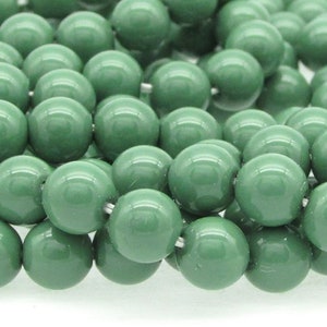 Pu&ograve; includere: Una collana di perline rotonde in vetro verde. Le perline sono lisce e lucide.