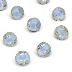 May include: Twelve iridescent blue glass buttons with a white center. The buttons are round and have a slightly raised edge.