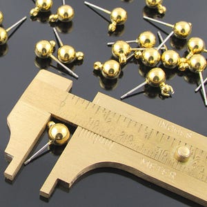 Post earring findings have a 6 millimeter shiny, gold plated brass ball and loop attached to a  7/16 inch stainless steel post.