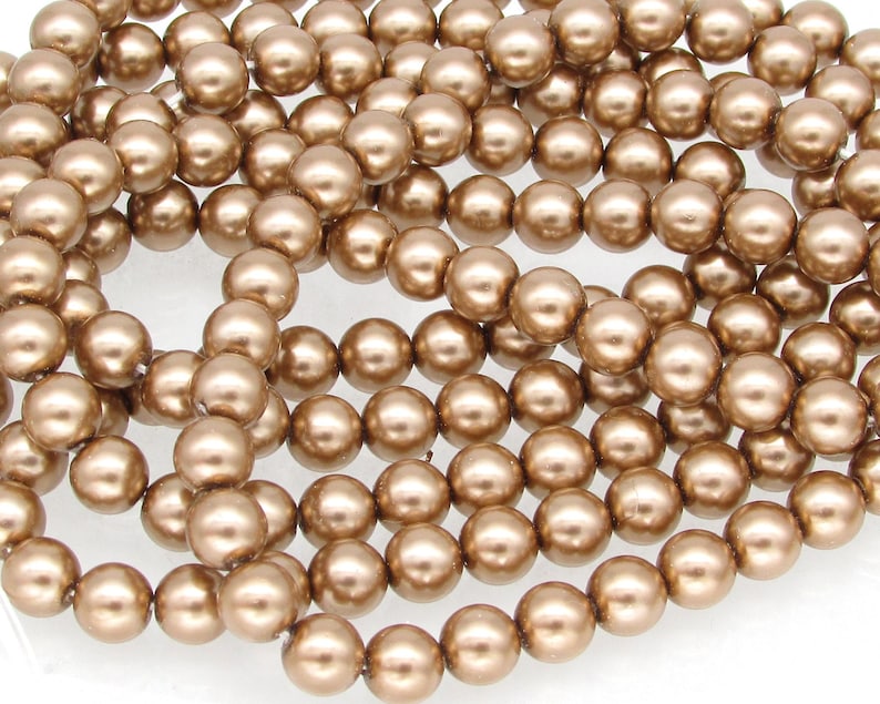 Bronze round Preciosa Crystal nacre pearls are premium imitation pearls with a crystal core and multiple layers of a smooth, durable coating that's highly resistant to scratches, ultraviolet radiation, and alcohol-based perfumes.