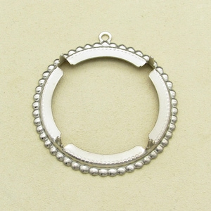 May include: A silver-colored metal pendant setting with a circular design. The setting features a beaded edge and a small loop at the top for attaching a chain or cord. The open center is designed to hold a round stone or other decorative element.
