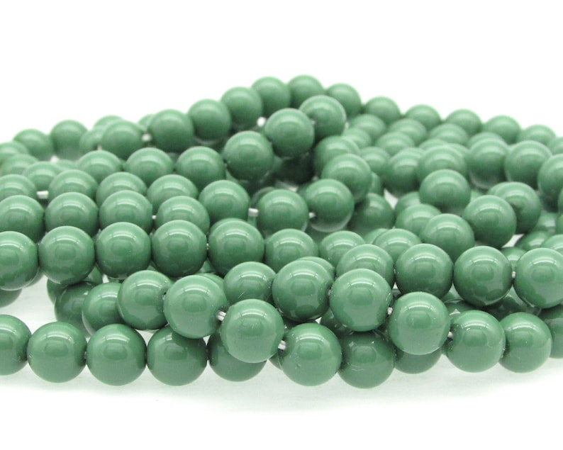 Pu&ograve; includere: Una collana di perline rotonde in vetro verde. Le perline sono lisce e lucide.