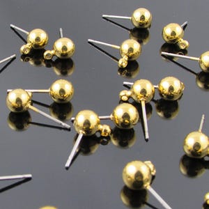 Post earring findings have a 6 millimeter shiny, gold plated brass ball and loop attached to a  7/16 inch stainless steel post.
