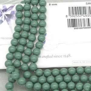 Pu&ograve; includere: Un filo di perline rotonde in vetro verde salvia da 8 mm. Le perline sono lisce e hanno una finitura opaca. Le perline sono infilate su un filo trasparente. Le perline sono confezionate in un sacchetto bianco con il testo "SAGE" e "8 mm" stampato su di esso.