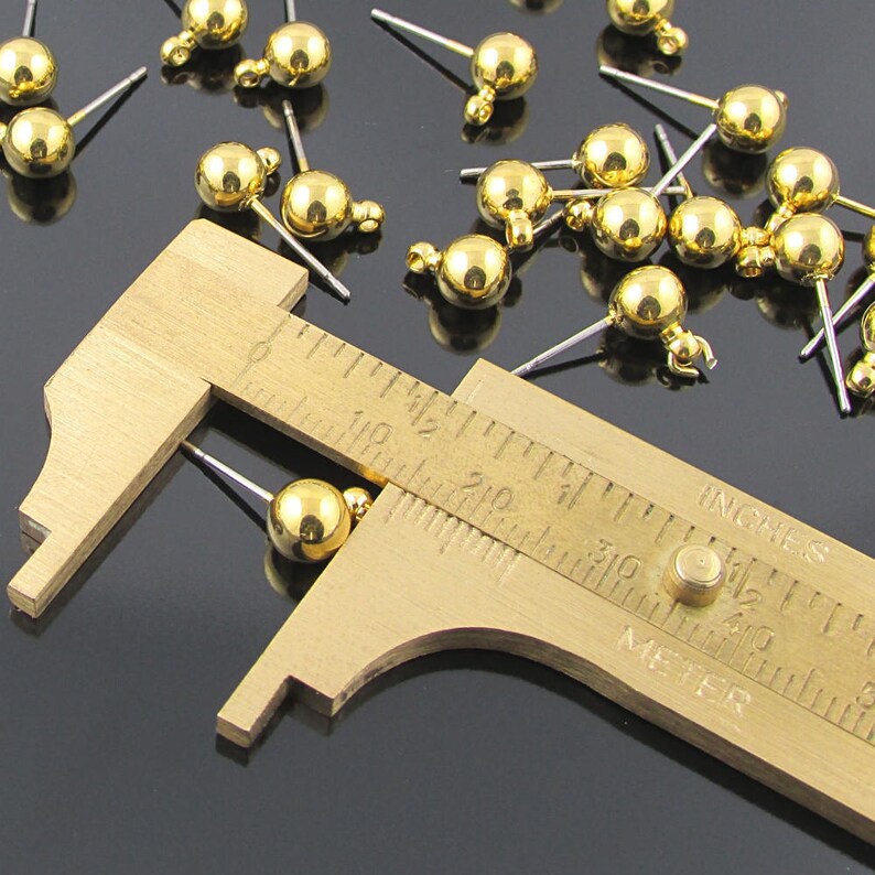 Post earring findings have a 6 millimeter shiny, gold plated brass ball and loop attached to a  7/16 inch stainless steel post.