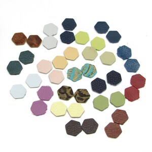 May include: Assortment of hexagon-shaped leather pieces in various colors, including brown, blue, green, pink, and yellow. The leather pieces are arranged in a circular pattern.