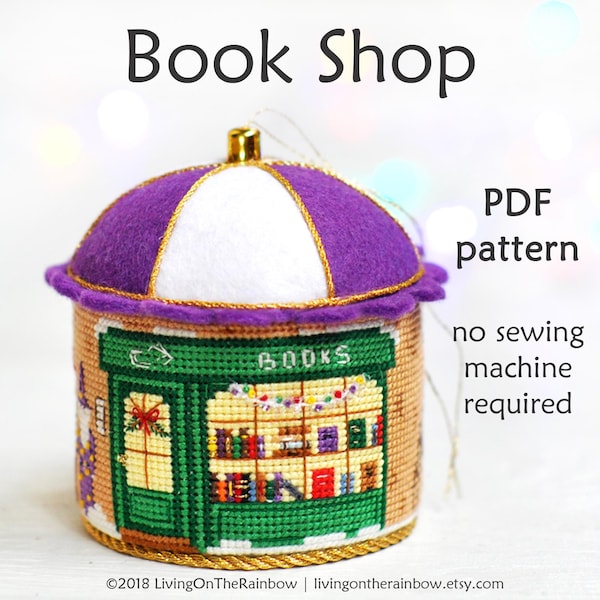 May include: A purple and white felt ornament shaped like a book shop with a sign that reads "BOOKS". The ornament is a PDF pattern for a no-sew project.