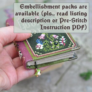 Op de afbeelding: Een klein, groen en paars boek met een bloemencross-stitch ontwerp. Het boek heeft een gouden bladwijzer met een groene kikkerbedel. De tekst op het boek luidt "Embellishment packs are available (pls., read listing description or Pre-Stitch Instruction PDF)".