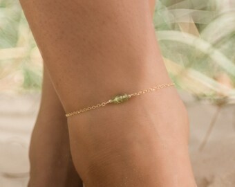 May include: A delicate gold anklet with a small green gemstone charm. 14k Gold Fill.