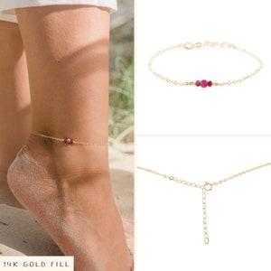 May include: Gold anklet with a delicate chain and three small pink gemstones. 14K Gold Fill.