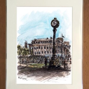 May include: Watercolor and ink sketch of a building and a clock tower. The artwork is framed in a white mat. The sky is light blue. The clock tower is black with a round clock face. The building has columns and a detailed facade.
