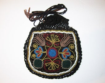 May include: A black beaded bag with a crocheted drawstring closure. The bag is decorated with colorful beads in a floral pattern.