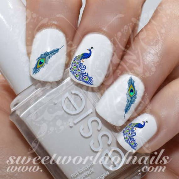 Beautiful girl with bright makeup, manicure design and peacock feather on  her face. Art nails. Photos shot in the studio Stock Photo - Alamy