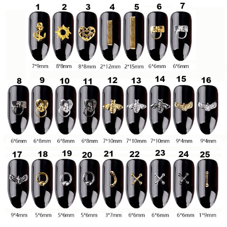 May include: A collection of 25 nail art charms in gold and silver tones, displayed on black nail polish. Designs include an anchor, sun, heart, bars, rings, bees, wings, crosses, and a curved line. Sizes vary from 1mm to 15mm.