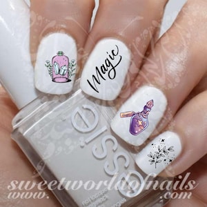 Puede incluir: Conjunto de cinco pegatinas para uñas con una botella rosa con cristales, una botella con una poción morada, una rama de hojas y la palabra "Magic" en cursiva.