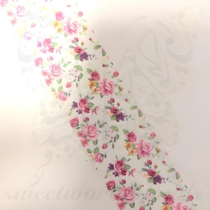 May include: A roll of floral patterned paper with pink, purple, and yellow roses and green leaves on a white background. The paper is translucent and decorated with the word "sweetworks".