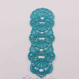 May include: Teal blue lace trim with a delicate floral pattern. The trim is made of a lightweight fabric and has a scalloped edge.