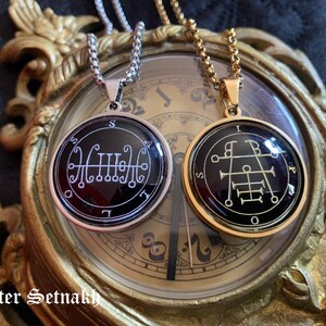 two pendants with intricate designs, placed on a clock with ornate decorations.