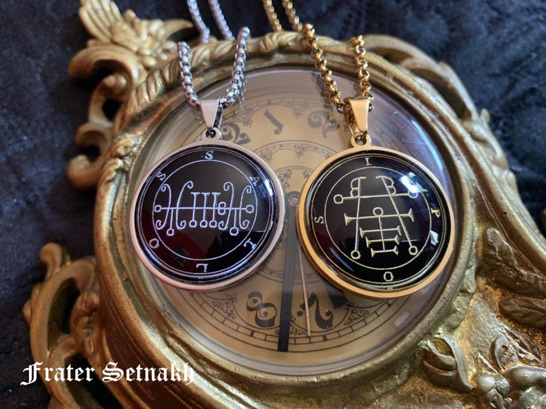 two pendants with intricate designs, placed on a clock with ornate decorations.