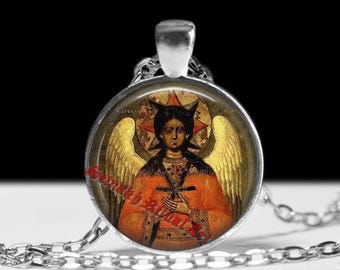 May include: Silver-toned pendant necklace featuring a religious icon. The round pendant showcases a detailed image of a figure with golden wings and a halo, wearing an orange robe. The chain is made of small, linked silver pieces.