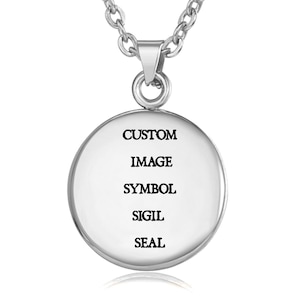 May include: A silver pendant necklace featuring a circular charm. The charm displays the words "CUSTOM IMAGE SYMBOL SIGIL SEAL" in black. The necklace chain is also silver.
