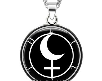 Op de afbeelding: Zilverkleurige ketting met een ronde hanger. De hanger heeft een zwarte achtergrond met een witte halve maan en een kruissymbool in een cirkel, met de letters "H L T" langs de rand. De tekst "Frater Setnakh Art" staat onderaan.