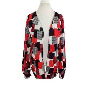 May include: A long-sleeved, open-front cardigan with a geometric pattern in red, black, and white. The pattern features squares and rectangles.