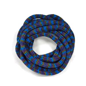 May include: A circular infinity scarf in shades of blue, purple, and green. The scarf is made of a thick, knitted material with a repeating chevron pattern. The scarf is a cozy accessory.