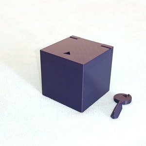 May include: A purple wooden box with a triangular opening on the top and a matching purple key.