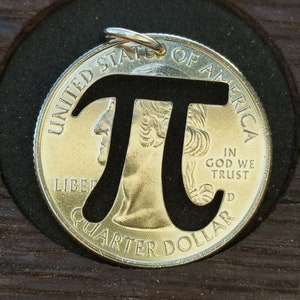 May include: A silver US quarter dollar coin with the mathematical symbol pi cut out of the center. The coin is in a wooden coin holder.