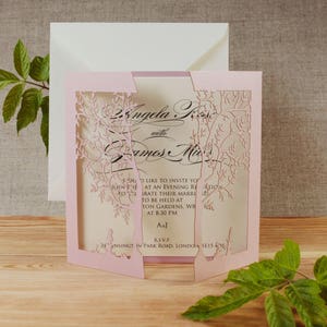 May include: Pink laser cut wedding invitation with a floral design. The invitation reads "Angela K with James M" and includes the text "You would like to invite you to join us at an evening reception to celebrate their marriage to be held at ... Gardens, W8 at 8:30 PM. AsJ. R.S.V.P. 24 ... in Park Road, London SE15 4J"