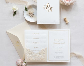 Puede incluir: Un conjunto de invitaciones de boda con un sobre crema, una tarjeta blanca con letras doradas y una tarjeta crema con un diseño recortado. La invitación incluye los nombres "James Landis & Kimberly Smith" y el texto "Request the pleasure of your company" y "RSVP by 1st April 2023".