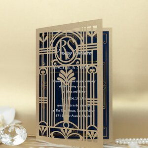 May include: A laser cut wedding invitation with a gold gate design and the initials "RS" in a circle. The invitation is on a blue background and includes the text "Evening Invitation" and the date "04.08.2025".