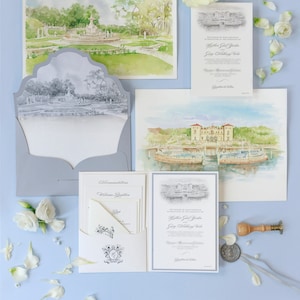 Puede incluir: Conjunto de invitaciones de boda con acuarelas de un jardín y un edificio frente al mar. El conjunto incluye tarjetas de invitación, un sobre y una tarjeta de alojamiento. También hay flores blancas y un sello de cera, todo sobre una superficie azul claro.