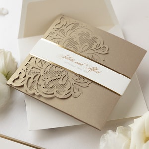 May include: Gold and white wedding invitation with a laser cut design. The invitation reads "Juliette and Albert, September 24th, 2023".