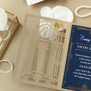 May include: A gold and blue wedding invitation with a laser cut design. The invitation features the text "Evening" and "Rachel &" in gold lettering on a navy blue background. The date "04.08.20" is also included.
