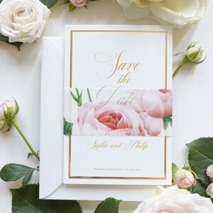 Op de afbeelding: Save the Date kaart met een gouden rand en een bloemmotief met roze rozen. De tekst luidt "Save the Date" en "Sophie en Philip" met de woorden "Formal Invitation to Follow" onderaan.