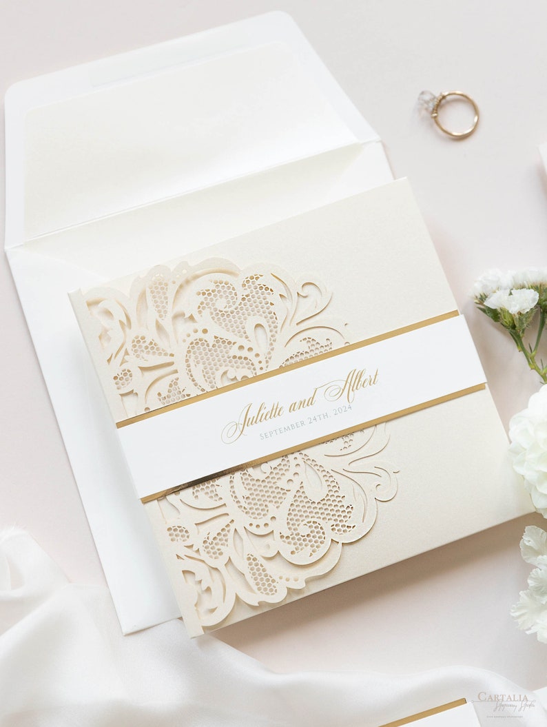 May include: A white and gold wedding invitation with a laser cut design. The invitation reads "Juliette and Albert, September 24th, 2024".