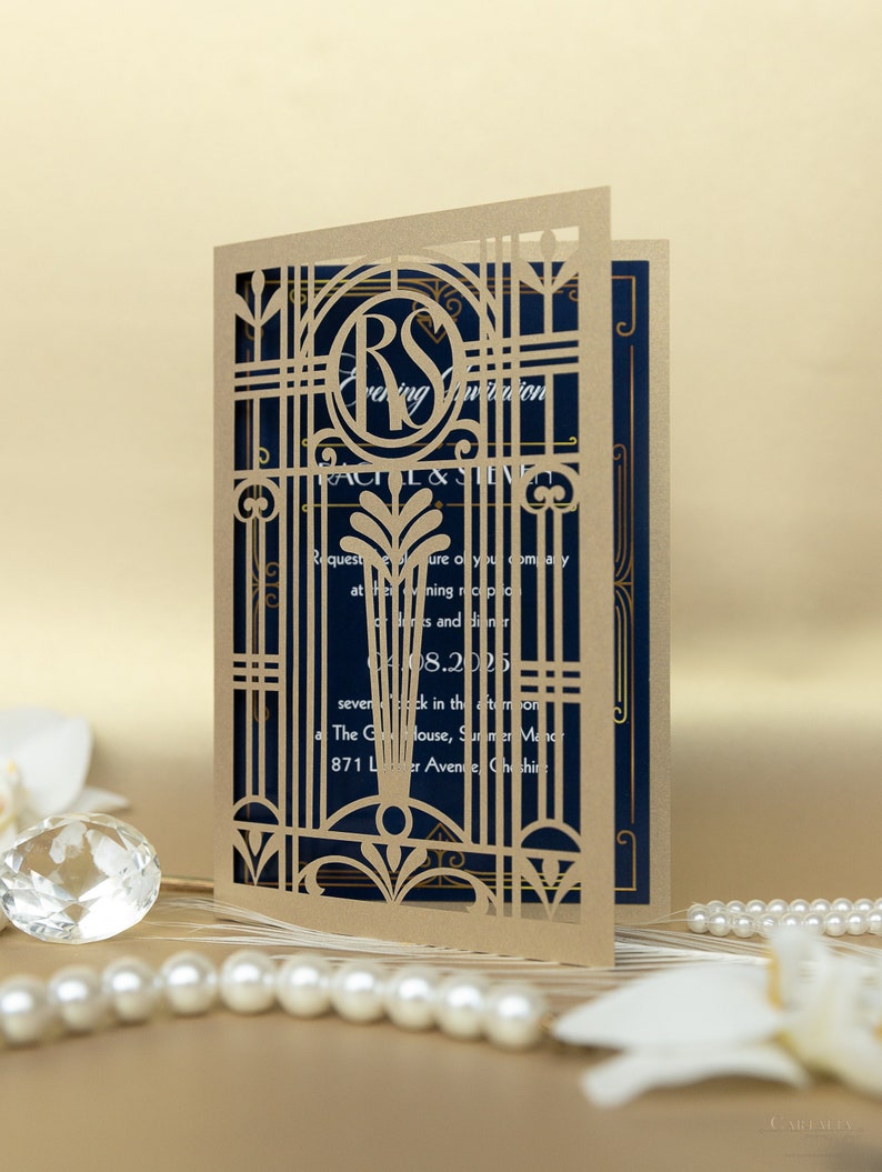 May include: A laser cut wedding invitation with a gold gate design and the initials "RS" in a circle. The invitation is on a blue background and includes the text "Evening Invitation" and the date "04.08.2025".