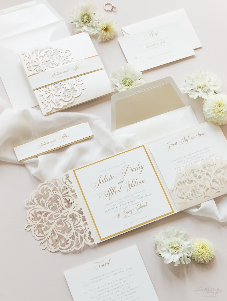 May include: A white wedding invitation suite with gold accents and a delicate lace design. The invitation features the names "Juliette Bailey and Albert Wilson" and the date "Saturday, September 24th, 2024". The invitation also includes the location "St. George Church".