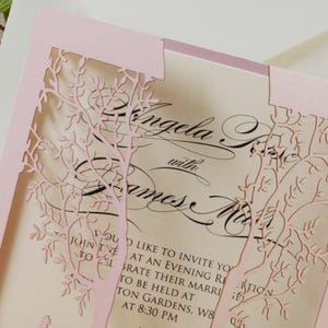 May include: Pink laser-cut wedding invitation with a floral design. The invitation reads "Angela with James". The text also includes "You are invited to join us to celebrate their marriage to be held at ... Gardens, W8 at 8:30 PM."