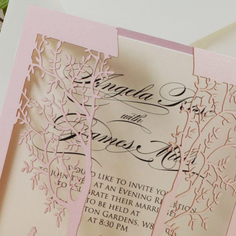 May include: Pink laser-cut wedding invitation with a floral design. The invitation reads "Angela with James". The text also includes "You are invited to join us to celebrate their marriage to be held at ... Gardens, W8 at 8:30 PM."